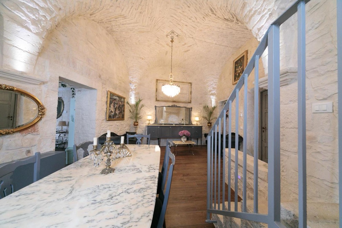 Il tavolo lungo in marmo della sala comune di Operà, sotto la volta imbiancata, dove si fa colazione