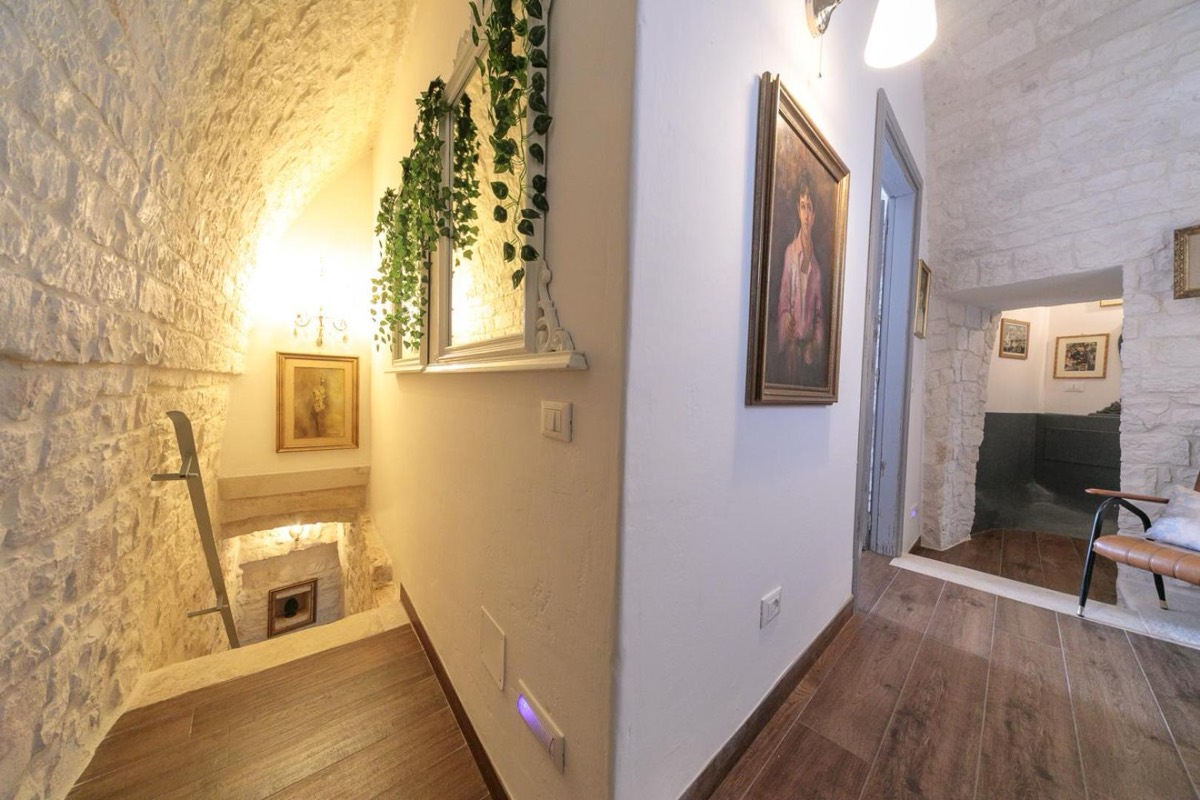 Corridoio con quadri incorniciati, poltrone e una pianta