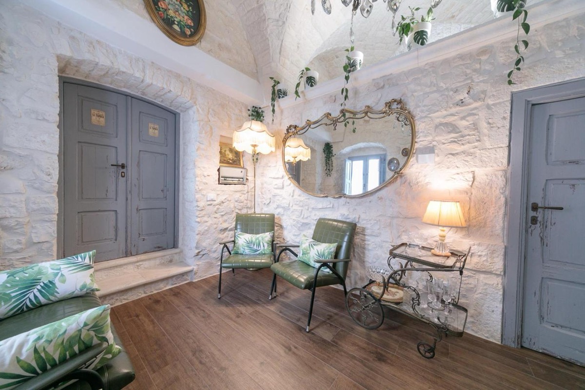 Salotto con poltrone d'epoca e una porta azzurra sotto la volta