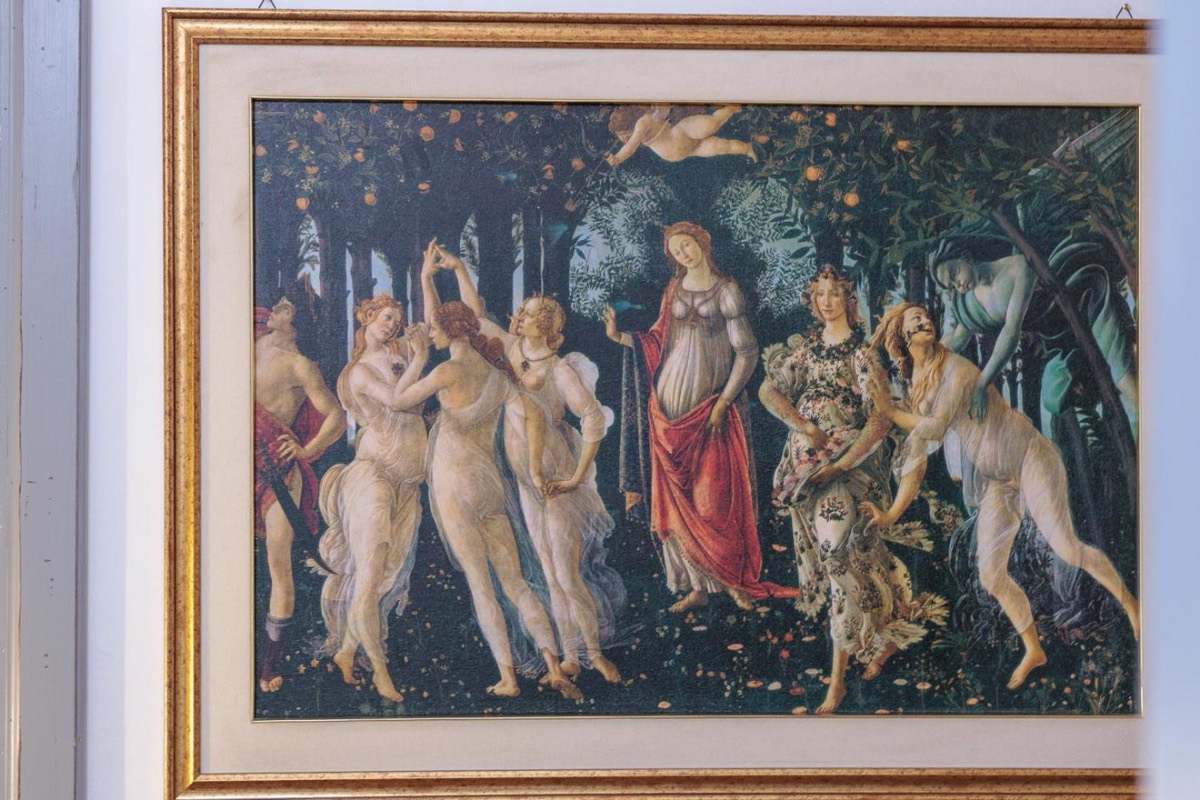 Stampa della Primavera del Botticelli incorniciata sul muro in pietra