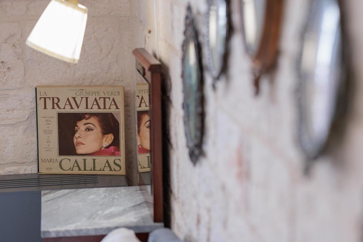 Manifesto de La Traviata con Maria Callas appeso al muro in pietra di una camera